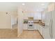 The kitchen features white cabinets and appliances, with a view of the living area beyond at 3129 White Rose Way, Henderson, NV 89014