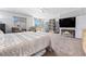 Spacious carpeted bedroom with a sitting area, natural light, and a large television at 3405 Brook Song Ave, North Las Vegas, NV 89081