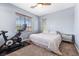 Comfortable bedroom featuring a ceiling fan, exercise bike, and a bright window with natural light at 3405 Brook Song Ave, North Las Vegas, NV 89081