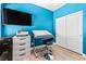 Bright blue bedroom with a modern desk, mounted TV, and sliding closet doors at 3405 Brook Song Ave, North Las Vegas, NV 89081
