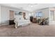 Bright bedroom featuring carpet floors, ceiling fan, a plush bed, and a comfortable massage chair at 3405 Brook Song Ave, North Las Vegas, NV 89081