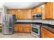 Kitchen with stainless steel refrigerator, range, microwave and wooden cabinets and granite countertops at 3405 Brook Song Ave, North Las Vegas, NV 89081