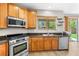 Kitchen with stainless steel appliances, wooden cabinets and countertops, and backyard view at 3405 Brook Song Ave, North Las Vegas, NV 89081