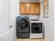 Laundry room features front loading washer and dryer and overhead cabinet storage at 3405 Brook Song Ave, North Las Vegas, NV 89081