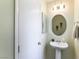 Cozy bathroom with pedestal sink, round mirror, and neutral color palette at 3425 Yorkminster St, Las Vegas, NV 89129