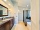 Elegant bathroom featuring dark cabinetry, granite countertops, and glass enclosed shower and bath at 3523 Calf Roper Ct, North Las Vegas, NV 89032