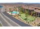Condominium complex with pool, putting green, and a road adjacent to the lake, desert landscape in the background at 4 Via Centrale # 1, Henderson, NV 89011