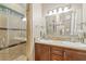 Bathroom with double sinks, marble countertops, modern lighting, and a glass enclosed shower with tile surround at 4 Via Centrale # 1, Henderson, NV 89011