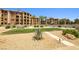 Exterior view of the condo building surrounded by landscaped grounds, mature trees, and desert plants at 4 Via Centrale # 1, Henderson, NV 89011