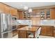 This kitchen features stainless steel appliances, wood cabinets, stone countertops, and modern lighting fixtures at 4 Via Centrale # 1, Henderson, NV 89011