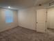 Carpeted bedroom featuring neutral walls, a window, and a view into another room at 4266 Yucca Brevi Ave, Las Vegas, NV 89139