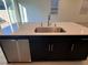 A kitchen island sink with stainless steel appliances and black cabinets at 4266 Yucca Brevi Ave, Las Vegas, NV 89139