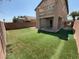 Backyard with artificial turf, privacy fence, and a covered patio area on a sunny day at 5316 Fireside Ranch Ave, Las Vegas, NV 89131