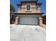 Beige two-story home featuring an attached two-car garage and well-maintained front yard at 5316 Fireside Ranch Ave, Las Vegas, NV 89131