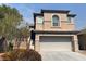 Tan two-story home showcasing a two-car garage and landscaped front yard, offering great curb appeal at 5316 Fireside Ranch Ave, Las Vegas, NV 89131