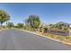 Inviting Nevada Ranch neighborhood entrance with mature landscaping and charming street lamps at 5521 Jackpot Winner Ln # 101, Las Vegas, NV 89122