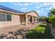 Charming home featuring a covered patio area with ample gravel, grassy area, and beautiful landscaping at 5601 Mackenzie Park Ct, Las Vegas, NV 89130