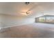 Bright and airy living room with vaulted ceilings, large windows, and plush carpeting at 5601 Mackenzie Park Ct, Las Vegas, NV 89130