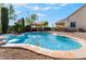 Inviting pool area with a rock waterfall feature, stone patio, and relaxing outdoor space at 5601 Mackenzie Park Ct, Las Vegas, NV 89130