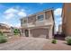 Two-story home with a two-car garage, tan stucco, concrete tile roof, and desert landscaping at 5616 Canoe Ridge Ct, Las Vegas, NV 89141