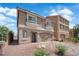 Two-story home featuring a two-car garage, desert landscaping, and small second story balconies at 5616 Canoe Ridge Ct, Las Vegas, NV 89141