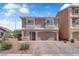 Two-story home featuring a two-car garage, desert landscaping, and small second story balconies at 5616 Canoe Ridge Ct, Las Vegas, NV 89141