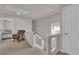 Bright upstairs hallway featuring an accent chair and access to bedrooms at 5616 Canoe Ridge Ct, Las Vegas, NV 89141