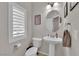 Cozy powder room features a pedestal sink, oval mirror, and neutral decor at 5616 Canoe Ridge Ct, Las Vegas, NV 89141