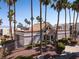 Low-rise exterior view of a desert community featuring palm trees, stucco walls, and a tile roof at 6800 E Lake Mead Blvd # 2076, Las Vegas, NV 89156