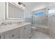 Bright bathroom featuring a large mirror, double vanity, and tub with tile surround at 6999 Montcliff Ave, Las Vegas, NV 89147