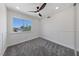 A bright bedroom with a large window, soft grey carpet, and ceiling fan at 6999 Montcliff Ave, Las Vegas, NV 89147