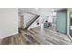 Open concept living area with wood floors, staircase, and adjacent kitchen with teal cabinets at 6999 Montcliff Ave, Las Vegas, NV 89147