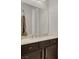 Modern bathroom vanity with dark wood cabinets, granite countertop, and towel rack at 7230 Fresh Harvest Ave, Las Vegas, NV 89131