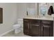 Bathroom with dark wood cabinet, toilet, and neutral colors at 7230 Fresh Harvest Ave, Las Vegas, NV 89131