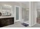 Modern bathroom with a glass-enclosed shower, dual vanity, and neutral gray tile at 7230 Fresh Harvest Ave, Las Vegas, NV 89131