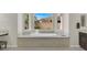 A luxurious soaking tub surrounded by three windows, with a view of the trees and the sky at 7230 Fresh Harvest Ave, Las Vegas, NV 89131