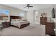 A spacious bedroom with plush carpeting, large windows, and a dark wood bedroom set at 7230 Fresh Harvest Ave, Las Vegas, NV 89131