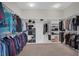 Walk-in closet features custom shelving, with storage for shoes and clothing, and neutral carpet at 7230 Fresh Harvest Ave, Las Vegas, NV 89131