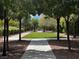 Peaceful community walking path with shaded areas provided by mature trees, creating a pleasant environment at 7230 Fresh Harvest Ave, Las Vegas, NV 89131