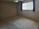 Empty bedroom features carpet, ceiling fan, and window for natural light at 745 Greenbriar Townhouse Way, Las Vegas, NV 89121