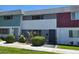 Exterior view of multi-colored townhouses with lawn and shrubbery in front of the units at 745 Greenbriar Townhouse Way, Las Vegas, NV 89121