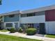 Exterior view of multi-colored townhouses with lawn and shrubbery in front on a clear day at 745 Greenbriar Townhouse Way, Las Vegas, NV 89121