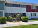 Exterior view of multi-colored townhouses with lawn and shrubbery in front at 745 Greenbriar Townhouse Way, Las Vegas, NV 89121