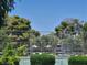 View of a community tennis court surrounded by trees and greenery at 745 Greenbriar Townhouse Way, Las Vegas, NV 89121