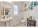 Charming powder room features a pedestal sink, decorative mirror, and neutral decor at 7948 Eastern Elk St, Las Vegas, NV 89149