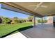 Backyard featuring lush artificial turf, a spacious covered patio, and mature landscaping at 8204 Turbys Treehouse Pl, Las Vegas, NV 89131