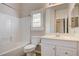 Bathroom with shower over tub, white cabinets, and bright window with shutters at 8204 Turbys Treehouse Pl, Las Vegas, NV 89131