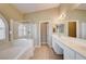 Bright bathroom with double sinks, soaking tub, and glass enclosed shower with shuttered window at 8204 Turbys Treehouse Pl, Las Vegas, NV 89131