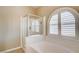Modern bathtub and enclosed shower are beside an arched window, which has plantation shutters for added privacy at 8204 Turbys Treehouse Pl, Las Vegas, NV 89131