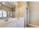Bright bathroom featuring a double vanity, walk-in shower, and a large window with plantation shutters at 8204 Turbys Treehouse Pl, Las Vegas, NV 89131